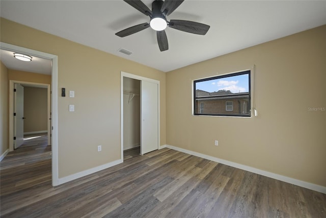 unfurnished bedroom featuring ceiling fan, dark wood-type flooring, and a closet