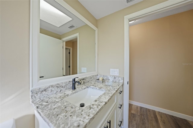 bathroom with hardwood / wood-style floors and vanity