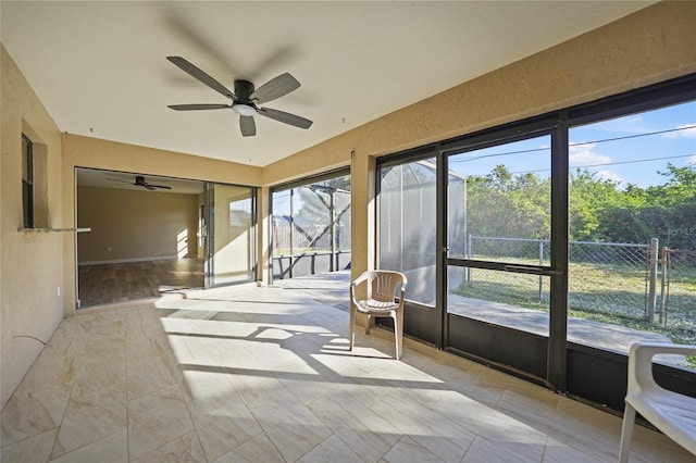 unfurnished sunroom with ceiling fan