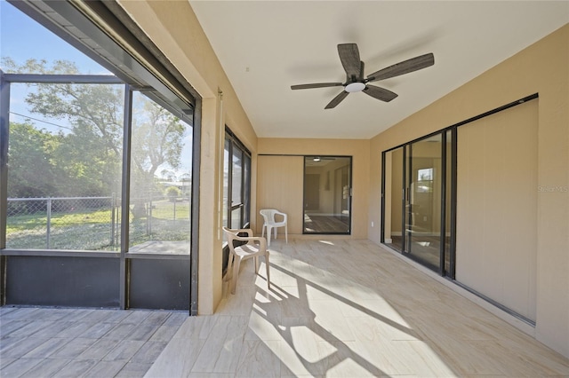 unfurnished sunroom featuring ceiling fan