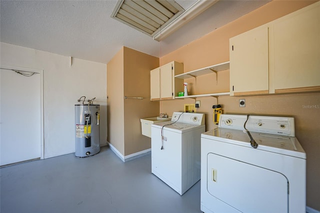 clothes washing area with cabinets, sink, washing machine and dryer, a textured ceiling, and water heater