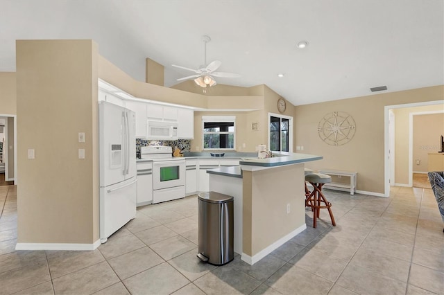 kitchen with white appliances, white cabinets, lofted ceiling, light tile patterned floors, and a kitchen bar