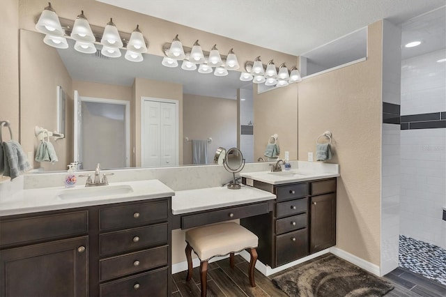 bathroom with vanity and a tile shower