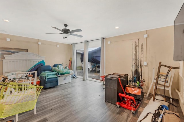 interior space featuring hardwood / wood-style flooring, ceiling fan, access to exterior, and expansive windows