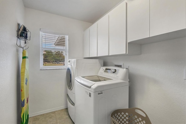 washroom featuring cabinets, washer and clothes dryer, and light tile patterned floors