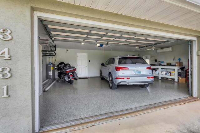 garage with a wall mounted air conditioner, a garage door opener, and electric water heater