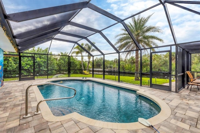 view of swimming pool with glass enclosure and a patio area