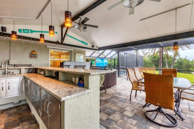 view of patio / terrace with area for grilling, ceiling fan, a wet bar, and glass enclosure