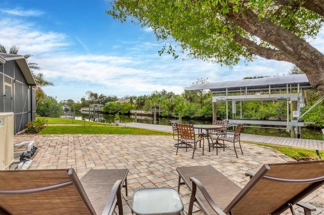 view of patio / terrace featuring a water view and glass enclosure