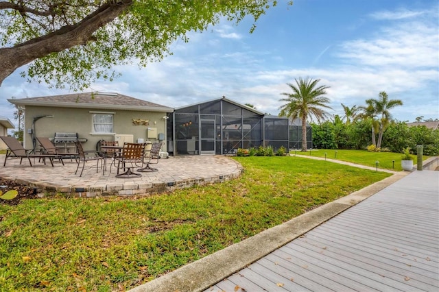 rear view of property with a patio, a yard, and a lanai