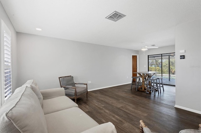 living room with ceiling fan and dark wood-type flooring