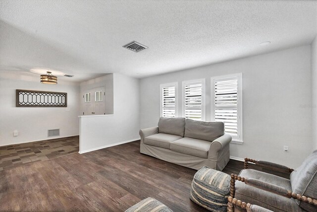 living room featuring a textured ceiling and dark hardwood / wood-style flooring