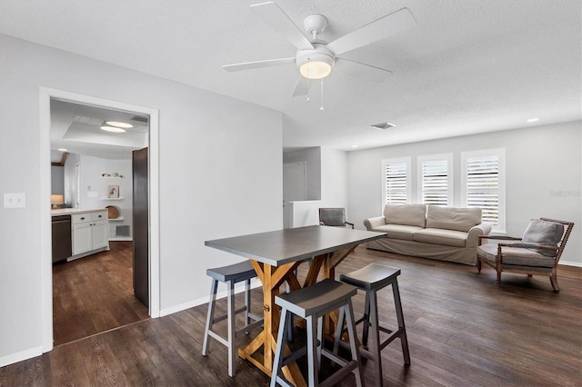 dining area with ceiling fan, a textured ceiling, and dark hardwood / wood-style flooring