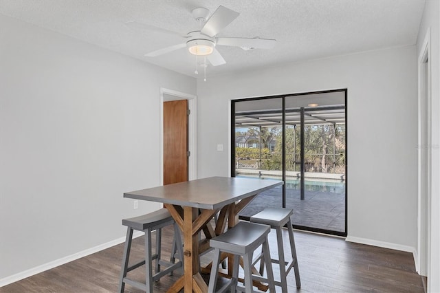 dining space featuring ceiling fan, a textured ceiling, and dark hardwood / wood-style floors