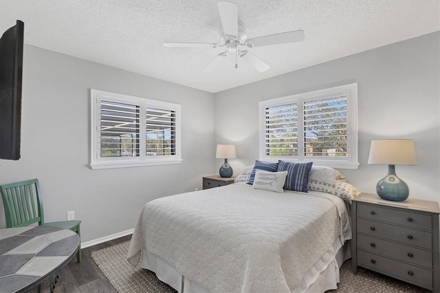 bedroom with ceiling fan, multiple windows, dark hardwood / wood-style flooring, and a textured ceiling