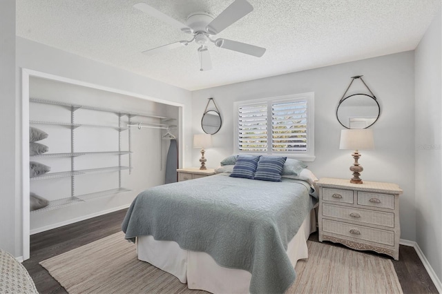 bedroom with ceiling fan, dark wood-type flooring, a textured ceiling, and a closet