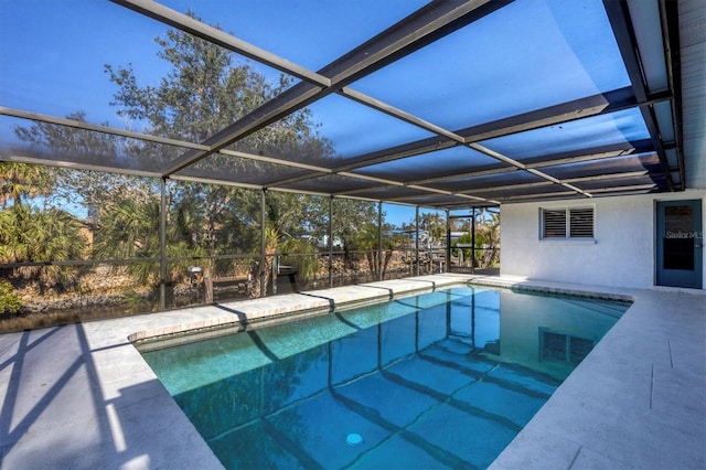 view of swimming pool featuring a patio and glass enclosure