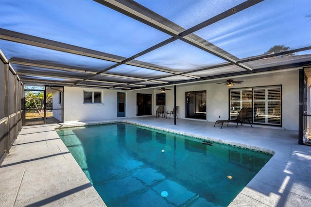 view of pool featuring glass enclosure, ceiling fan, and a patio