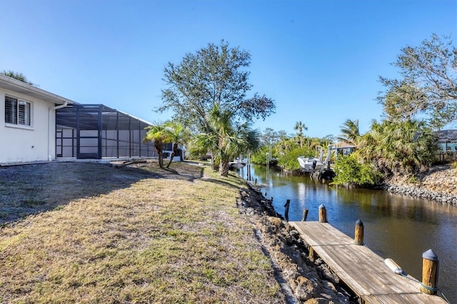 view of yard featuring a boat dock, a lanai, and a water view