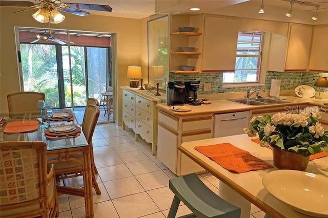 kitchen featuring dishwasher, decorative backsplash, plenty of natural light, and light tile patterned floors