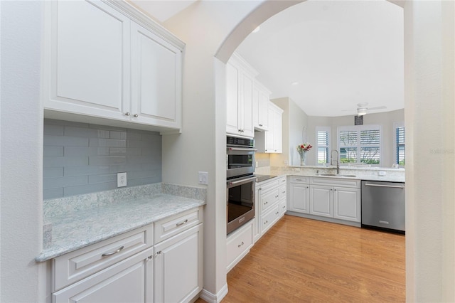 kitchen featuring appliances with stainless steel finishes, light wood-type flooring, white cabinetry, and sink