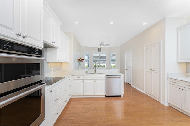 kitchen featuring light wood-type flooring, stainless steel appliances, ceiling fan, sink, and white cabinetry