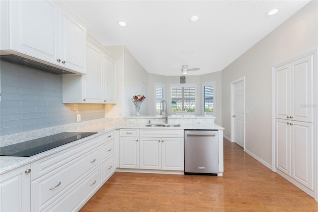 kitchen featuring kitchen peninsula, dishwasher, sink, and light hardwood / wood-style flooring