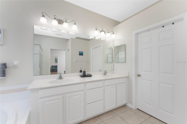 bathroom featuring tile patterned flooring, vanity, and tiled bath