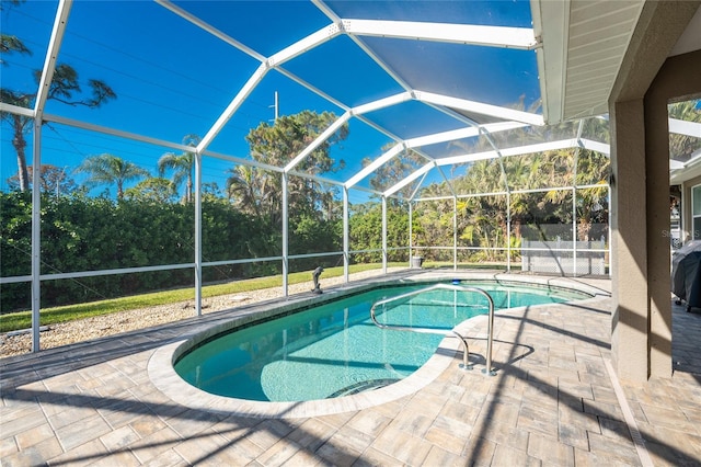 view of swimming pool featuring glass enclosure and a patio