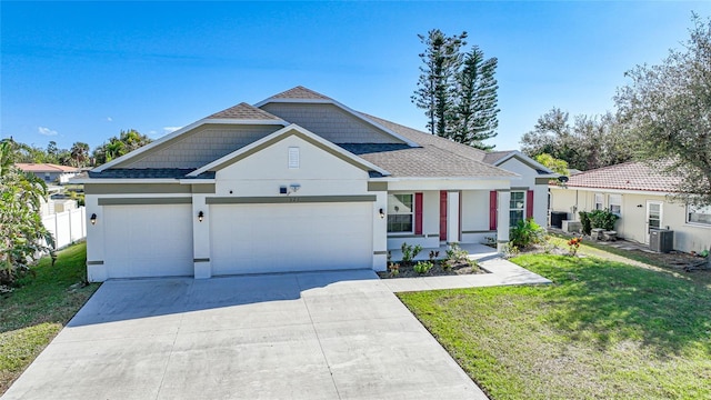 view of front of house with a front yard, central AC unit, and a garage