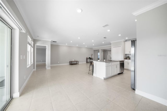 kitchen featuring sink, white cabinetry, ornamental molding, and an island with sink