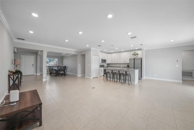 tiled living room featuring crown molding and sink