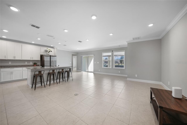 kitchen featuring a kitchen breakfast bar, light tile patterned flooring, stainless steel refrigerator with ice dispenser, white cabinets, and ornamental molding