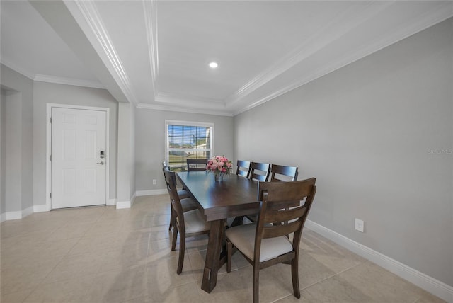 tiled dining area with a raised ceiling and crown molding