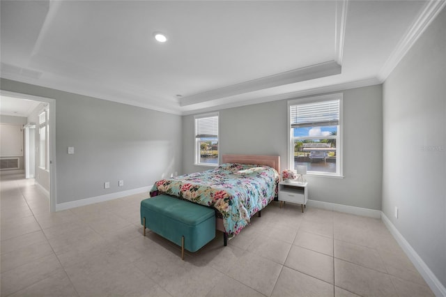 bedroom with a raised ceiling, multiple windows, and ornamental molding