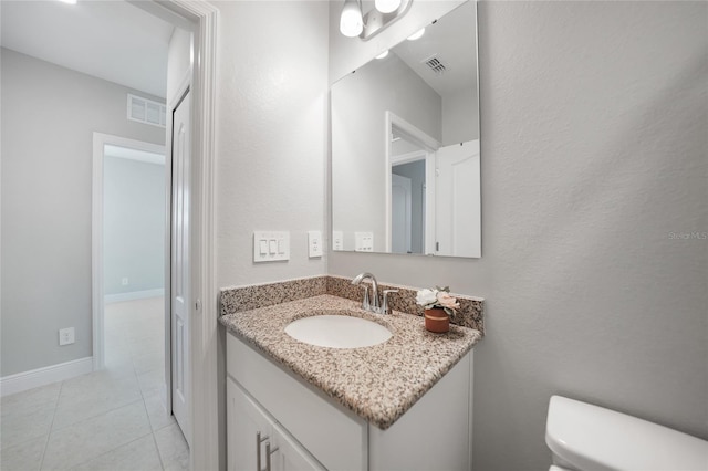 bathroom with tile patterned flooring, vanity, and toilet