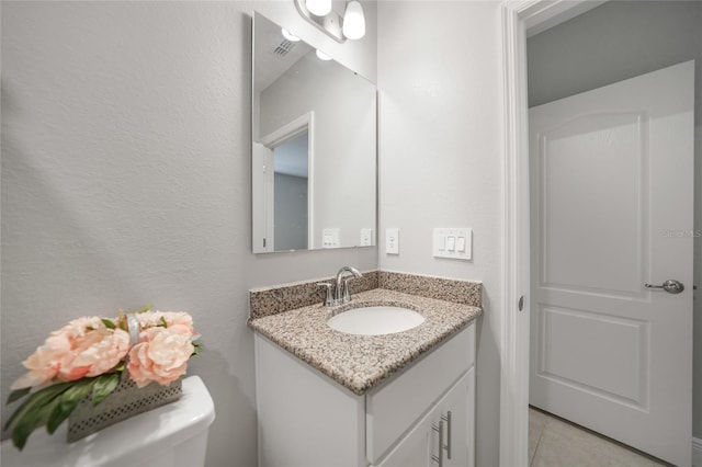 bathroom featuring tile patterned floors, vanity, and toilet