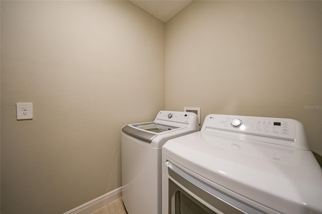 laundry room with light tile patterned flooring and separate washer and dryer