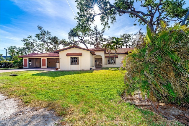 mediterranean / spanish-style house featuring a front yard and a carport