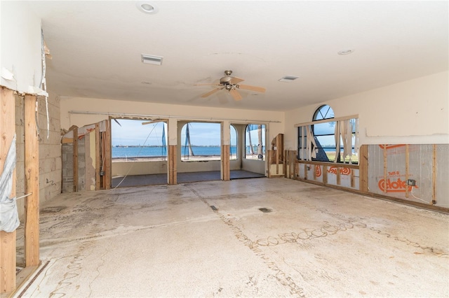 misc room with a water view and ceiling fan