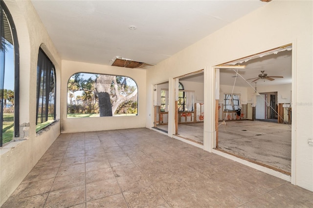 unfurnished sunroom featuring ceiling fan