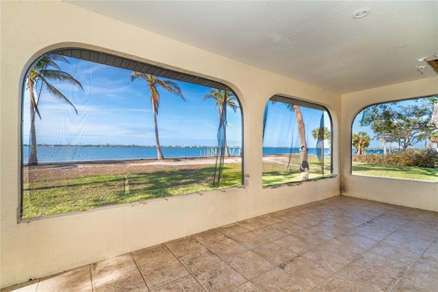 unfurnished sunroom with a water view