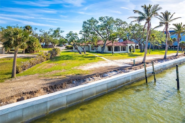 view of dock with a lawn and a water view