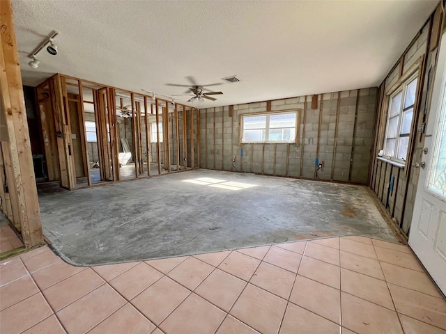 unfurnished room featuring ceiling fan and a textured ceiling