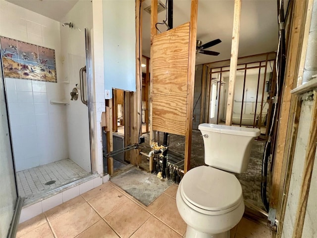 bathroom with tile patterned flooring, toilet, ceiling fan, and walk in shower