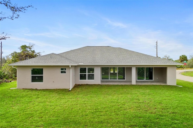 back of property with a yard and a patio area