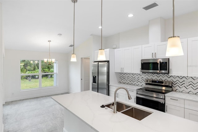 kitchen featuring white cabinets, sink, appliances with stainless steel finishes, and vaulted ceiling