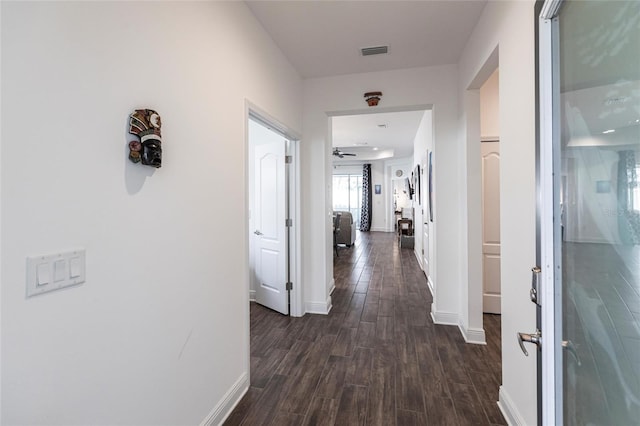 corridor with dark hardwood / wood-style flooring