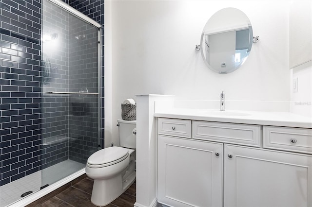 bathroom with wood-type flooring, vanity, toilet, and an enclosed shower