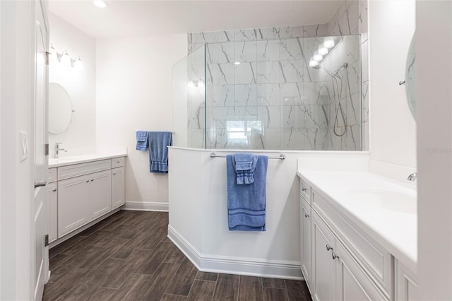 bathroom with a tile shower and vanity